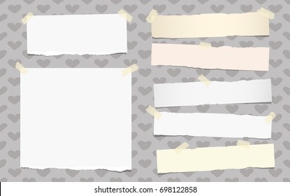 White ripped note, copybook, notebook paper strips stuck with sticky tape on grey background.
