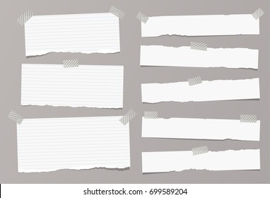 White ripped ruled, lined note, copybook, notebook paper strips stuck with sticky, adhesive tape on grey background.