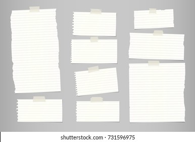 White ripped striped note, notebook paper for message or text stuck with sticky tape on gray background.