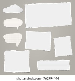 White ripped strips, notebook, note paper for text or message stuck on gray background.