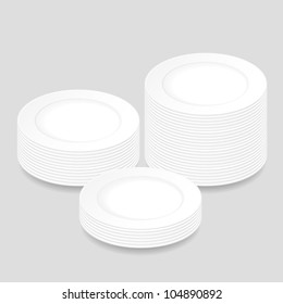 White Round Plates, Stacked In Three Piles Of Different Heights