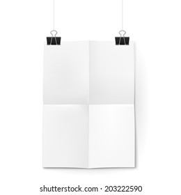 White sheet of paper folded in four. The paper hangs on black binder clips.