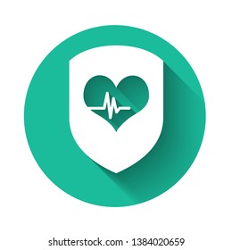 White Shield and heart rate icon isolated with long shadow. Health protection concept. Health care. Green circle button. Vector Illustration