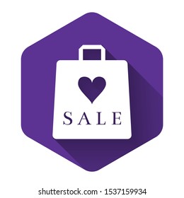 White Shoping bag with an inscription Sale icon isolated with long shadow. Handbag sign. Woman bag icon. Female handbag sign. Purple hexagon button. Vector Illustration