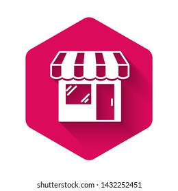 White Shopping building or market store icon isolated with long shadow. Shop construction. Pink hexagon button. Vector Illustration