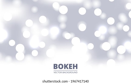 White and silver bokeh background. Holiday glowing silver lights with sparkles. Festive defocused lights. Blurred bright abstract bokeh on light background.