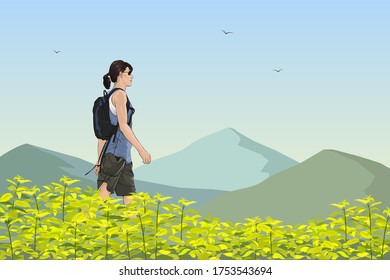 A white slender woman of sports physique with a backpack behind her back goes through the high grass. In the background is a mountains and blue sky.