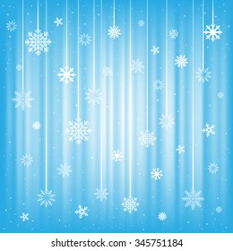 White snowflakes hanging on strings on a blue mesh background