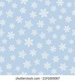 White snowflakes on pastel blue background seamless pattern.  Best for textile, wallpapers, wrapping paper and seasonal decoration.