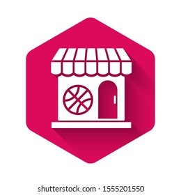 White Sports shop and basketball ball icon isolated with long shadow. Sport store. Pink hexagon button. Vector Illustration