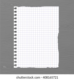White squared ripped notebook paper sheet is stuck on gray wooden wall, desk