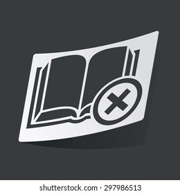 White sticker with black image of book with cross, on black background