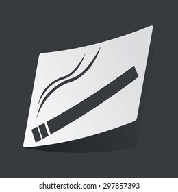 White sticker with black image of burning cigarette, on black background