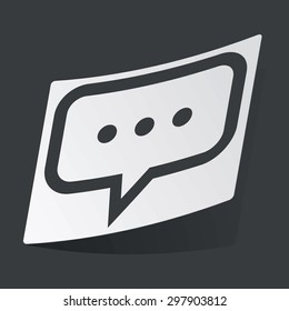 White sticker with black image of chat bubble with dots, on black background