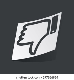 White sticker with black image of dislike symbol, on black background