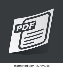 White sticker with black image of document page and text PDF, on black background