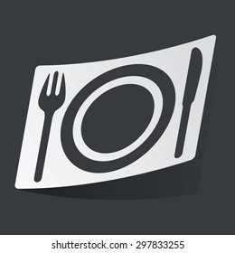 White sticker with black image of fork, plate, knife, on black background