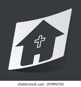 White sticker with black image of house with christian cross, on black background