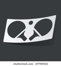 White sticker with black image of ping pong rackets, on black background