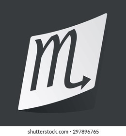 White sticker with black image of Scorpio zodiac symbol, on black background