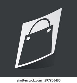 White sticker with black image of shopping bag, on black background