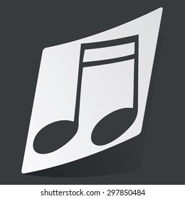 White sticker with black image of sixteenth note, on black background