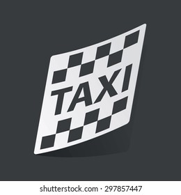 White sticker with black image of taxi logo, on black background