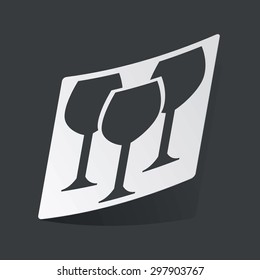 White sticker with black image of three wine glasses, on black background
