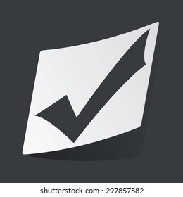 White sticker with black image of tick mark, on black background