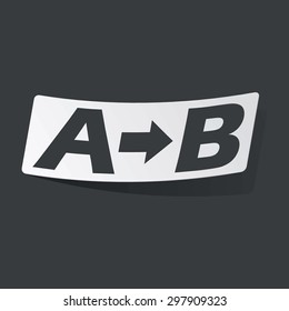 White sticker with black letters A, B and arrow, on black background