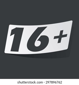 White sticker with black text 16 plus, on black background