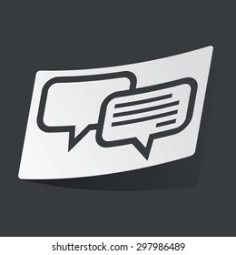 White sticker with black two chat bubbles, one with text, on black background