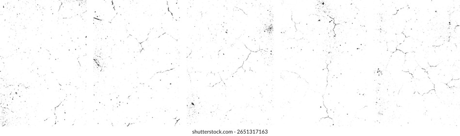 Uma superfície branca com numerosas rachaduras pretas finas e manchas dispersas.
