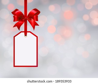 White tag isolated on bokeh background with red  ribbon