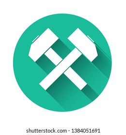 White Two crossed hammers icon isolated with long shadow. Tool for repair. Green circle button. Vector Illustration