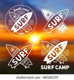 White vector crossing surfing boards logo templates set with hand drawn sign Love, Live, SURF on blurred sunset beach background