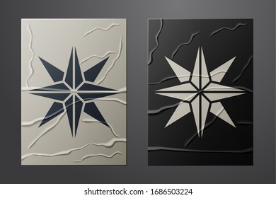 White Wind rose icon isolated on crumpled paper background. Compass icon for travel. Navigation design. Paper art style. Vector Illustration
