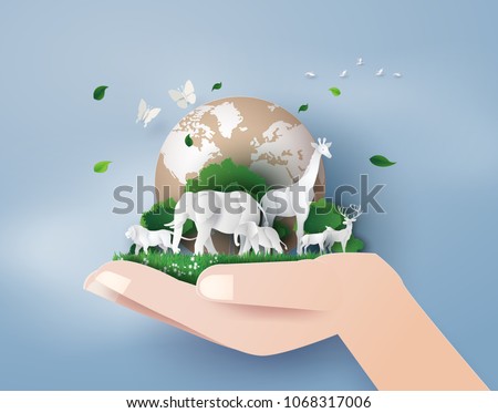 Wild animals standing on green earth held by a hand, symbolizing environmental care.