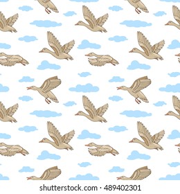 Wild ducks flying in the sky among the clouds. Seamless background with birds. Repetitive elements. Mallard drawing. Children's colored illustration. Vector.