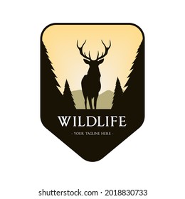 Wildlife Logo Design with a deer and fir tree silhouette and framed with a shield