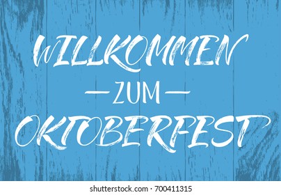 Willkommen zum Oktoberfest (German) / Welcome to Oktoberfest (English) lettering on blue wood background. Handwritten modern calligraphy, brush painted letters. Vector illustration. 