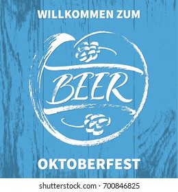 Willkommen zum Oktoberfest (German) / Welcome to Oktoberfest (English). Beer lettering with hand drawn hop cones on blue board texture. Modern calligraphy, brush painted letters. Vector illustration.