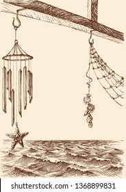 Wind chimes on the porch of a beach house. Sea view in the background