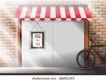 Window display front ,Sale poster and bicycle on brick wall.