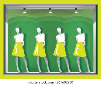 window display with mannequins and text SALE on a green background 