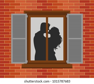 Window in the house at night. Silhouettes of the guy and the girl who kiss. Valentine's Day Celebration.