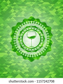 wine cup icon inside green emblem with triangle mosaic background