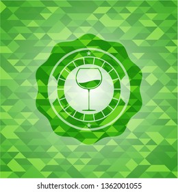 wine cup icon inside green emblem with triangle mosaic background