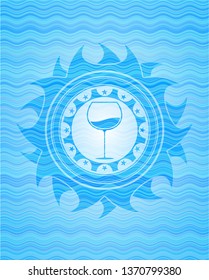 wine cup icon inside light blue water wave badge background.