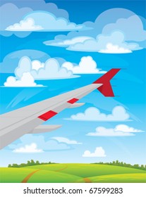 Wing of flying airplane on blue, white clouds and green meadow